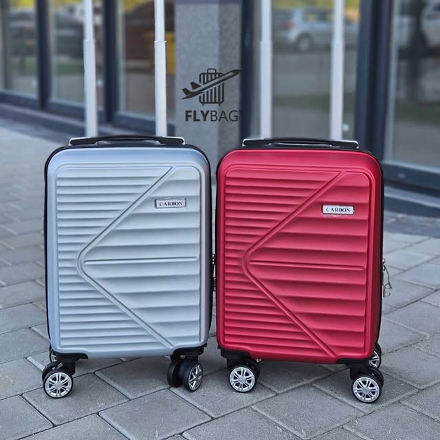Біла та червона валізи біля магазину Flybag